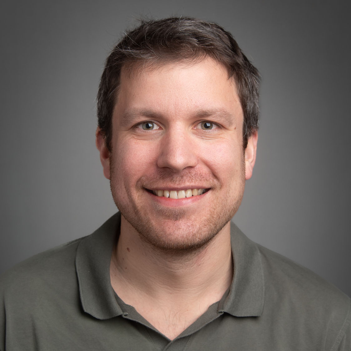 a portrait of Professor Jack Satterlee in front of a grey studio background