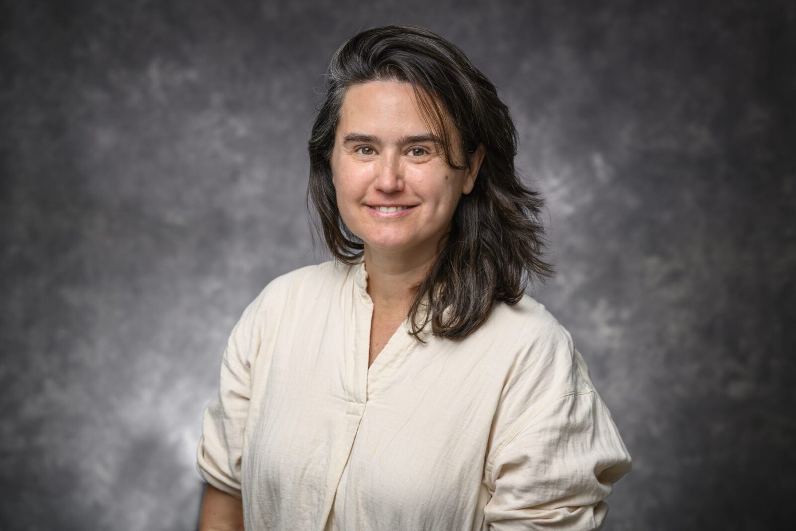 Portrait of Anne Pringle on a grey studio background.
