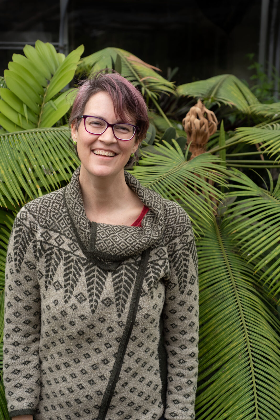 Portrait of Kate McCulloh in front of greenery.